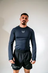 Remera de lycra negra de manga larga con logo blanco en el pecho.