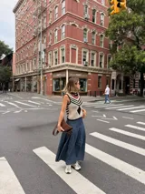 Falda larga negra con diseño de caderín y tablas.