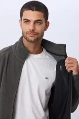 Campera gris de polar texturado liviano, con cuello alto, cierre frontal y bolsillos laterales con cierre.