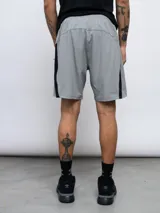 Short deportivo Umbro negro con paneles laterales en gris claro. Confeccionado en tejido de elasticidad en cuatro direcciones.