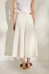 Falda larga de jean color marrón, de corte acampanado con costuras pespuntadas visibles y diseño de tiro medio.