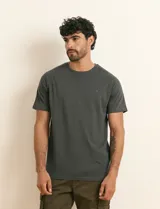 Remera básica de algodón color beige, de manga corta, con cuello redondo y un pequeño detalle bordado en el pecho.