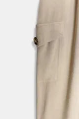 Mono largo de cuello solapa y escote en pico cruzado, con mangas cortas. Presenta bolsillos laterales de plastrón con solapa y botones, y un cinturón del mismo tejido para ajustar en la cintura. Cierre frontal con cremallera y botón interior.