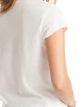 Blusa de manga corta con cuello redondo, completamente cubierta de lentejuelas blancas. Cuenta con forro interno a tono y un ajuste clásico al cuerpo.