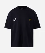 Remera de corte oversized confeccionada en mezcla de algodón y poliéster. Presenta cuello redondo, mangas cortas con hombros caídos y diseño estampado en la espalda con la frase 'LA THE START OF A NEW ERA' acompañada de estrellas amarillas.