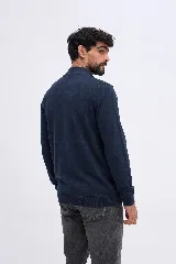 Campera de tejido liviano de punto, color negro, con cierre frontal, cuello alto, mangas largas y puños ajustados, con detalle de logo bordado en el pecho.