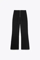 Pantalón de vestir color crudo, de tiro alto y pierna acampanada.