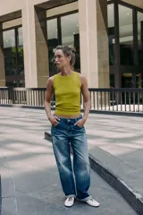 Top de punto color amarillo mostaza, con cuello redondo y manga sisa. Acabados en rib a tono.