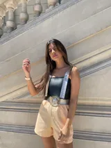 Top corto negro de ecocuero con tirantes finos plateados y espalda descubierta.