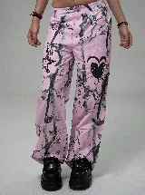 Pantalon de corte recto y tiro alto con estampado de camuflaje en tonos rosados y negros, con detalles gráficos de corazones y estrellas.