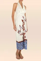 Vestido largo color blanco con estampado de flores y hojas en tonos marrones y celestes. Tiene escote halter y corte ajustado al cuerpo. Incluye cinturón fino.