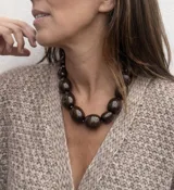 Collar de diseño artesanal compuesto por múltiples hileras de cuentas de resina pulida en una paleta de colores vibrantes que incluye tonos marrones, grises, verdes, naranjas y bordó.