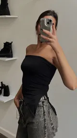 Top strapless negro de corte asimétrico con terminación en punta en el frente.