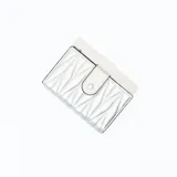 Billetera plateada con diseño geométrico acolchado y cierre con broche a presión.