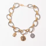 Collar corto de eslabones gruesos dorados y plateados, con tres dijes colgantes: uno cuadrado dorado, uno redondo dorado y uno redondo plateado.