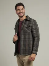 Camisa a cuadros verde, marrón y gris, de corte recto, con cuello clásico, cierre frontal con botones, dos bolsillos con solapa abotonada en el pecho y mangas largas con puños abotonados.