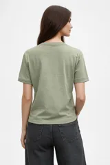 Remera de algodón color negro, de corte holgado y manga corta, con cuello a la base. Presenta un estampado frontal de una rana con sombrero vaquero y la frase 'hold on partner, im overstimulated'.