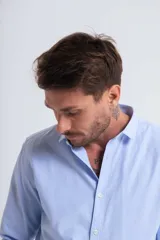 Camisa celeste de manga larga con cuello abotonado.