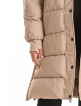 Campera puffer larga de abrigo marca BCBG Maxazria, color beige. Cuenta con capucha desmontable, cuello alto envolvente, cierre frontal bidireccional con solapa de botones a presión, bolsillos laterales, puños internos elastizados y tajos laterales con cierre en el bajo.