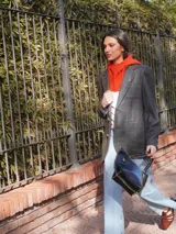 Blazer oversize bicolor de la marca Agnés, con diseño de doble faz que combina un lado en tejido gris oscuro liso y otro lado en tejido tostado con patrón de rayas diplomáticas. Cuenta con solapas clásicas, cierre frontal de dos botones y bolsillos aplicados.