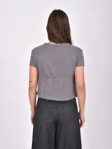 Remera gris oscuro de corte peplum con cuello redondo y mangas cortas, confeccionada en tejido de punto con textura.