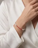 Pulsera de plata 925 con diseño combinado de perlas blancas naturales y piedras esféricas de color rojo, separadas por pequeñas cuentas plateadas.