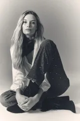 Jean tiro alto de denim azul rígido, con lavado oscuro y apliques de brillos. De pierna recta.