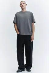 Remera de algodón de peso medio color gris, con cuello redondo ribeteado, hombros caídos, mangas cortas y corte relajado.