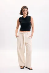 Pantalón casual beige de corte recto, con bolsillos laterales y pespuntes en contraste.