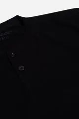 Remera manga larga color crema con cuello henley y cartera de botones frontales, confeccionada en tejido con textura.