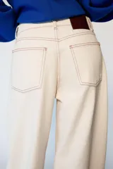 Jeans de tiro medio con diseño barrel, corte holgado que se estrecha hacia el tobillo y cinco bolsillos. Presenta costuras a contraste y cierre frontal con cremallera y botón.