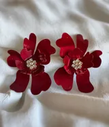 Par de aros con forma de flor roja y centro con strass.