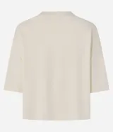 Remera de modal color crudo, con diseño minimalista, calce amplio, cuello redondo y mangas cortas amplias con hombros caídos.