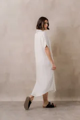 Vestido midi camisero de corte oversize color blanco, con cierre frontal de botones, mangas cortas con vuelta y ruedo redondeado.
