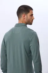 Remera polo de manga larga confeccionada en tejido piqué de algodón. Presenta cuello clásico, cierre frontal con botones y logo bordado en el pecho.