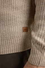 Sweater verde de punto inglés con cuello alto y cierre metálico frontal. Tiene mangas largas y terminaciones en punto canalé.