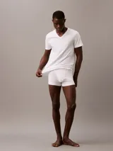 Pack de tres remeras Calvin Klein blancas de algodón, con cuello en V y logo bordado en el dobladillo.