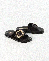 Sandalias de cuero color negro, de diseño plano con una tira ancha en el empeine y una hebilla metálica dorada grande como detalle.