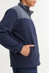 Campera de polar con cierre frontal completo, cuello alto y diseño bicolor en gris y negro. Cuenta con bolsillos laterales y puños elásticos.