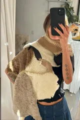 Ruana artesanal confeccionada con piezas de napalán unidas mediante técnica de crochet, con diseño de parches en tonos tierra y texturas de piel sintética.