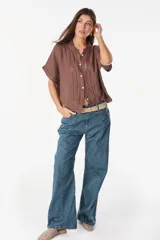 Pantalón jean de corte amplio y relajado, color azul oscuro, con bolsillos traseros grandes y detalles de costuras marcadas.