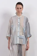 Camisa de manga larga con cuello mao, botones en el frente, fit holgado y dos bolsillos en la delantera.