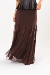 Pollera larga color chocolate confeccionada en microtul, totalmente forrada, con diseño fluido y volados en cascada que aportan movimiento.