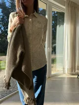 Camisa de lino con estampado floral liberty, cuello clásico, cierre frontal con botones y aplique bordado de flor de encaje en el pecho.