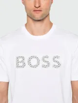 Remera blanca de manga corta con cuello redondo y el logo "BOSS" estampado en el pecho con un patrón de puntos en tonos grises y negros.