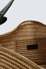 Bolso de hombro negro con acabado trenzado. Tiene un compartimento principal con cierre de cremallera y un bolsillo plano en el interior. El asa de hombro es ajustable.