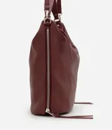 Bolso tipo hobo de gran tamaño en color bordó, confeccionado en poliuretano. Presenta una estructura desestructurada, cierre superior, correas dobles (una de mano y una larga desmontable) y cierres laterales decorativos con tiradores.