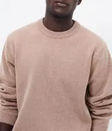 Suéter masculino de cuello redondo y manga larga, confeccionado en tejido fleece con textura suave. Presenta puños y ruedo acanalados, con un diseño liso y minimalista.