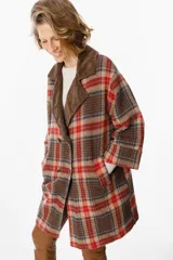 Blazer de corte relajado con estampado de cuadros en tonos marrones, rojos y azules. Presenta solapas de pana en color marrón chocolate, cierre frontal con botones y bolsillos laterales.