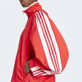 Campera Adidas Adilenium Season 3 roja con cuello alto y logo bordado en el pecho. Diseño oversize con cierre frontal, mangas largas con cremalleras bidireccionales y puños elásticos.